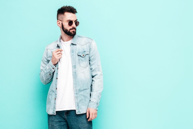 Portrait of handsome confident model Sexy stylish man Fashion hipster male posing near wall in studio Isolated