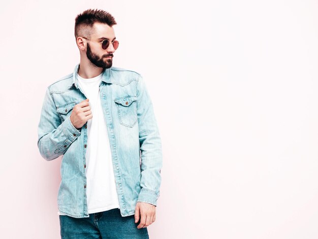 Portrait of handsome confident model Sexy stylish man Fashion hipster male posing near wall in studio Isolated