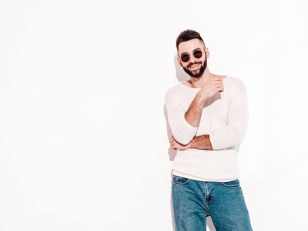 Portrait of handsome confident model Sexy stylish man Fashion hipster male posing near wall in studio Isolated