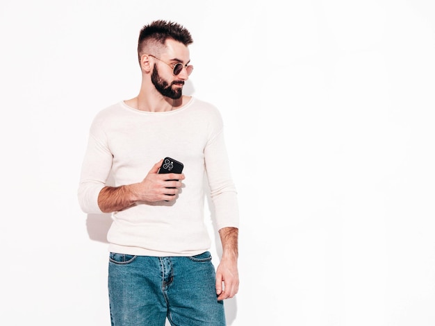 Portrait of handsome confident model Sexy stylish man Fashion hipster male posing near wall in studio Isolated