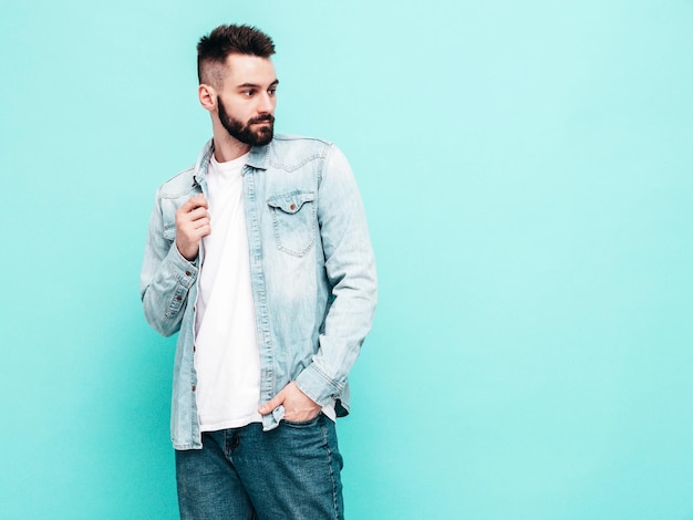 Portrait of handsome confident model Sexy stylish man Fashion hipster male posing near wall in studio