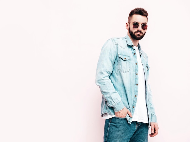 Portrait of handsome confident model Sexy stylish man Fashion hipster male posing near wall in studio