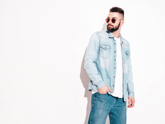 Portrait of handsome confident model Sexy stylish man Fashion hipster male posing near wall in studio