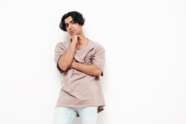 잘 생긴 자신감이 세련된 힙스터 램버섹슈얼 모델의 초상 사이즈 티셔츠와 청바지를 입은 섹시한 남자 패션 남성 스튜디오에서 격리 흰색 벽 근처 포즈