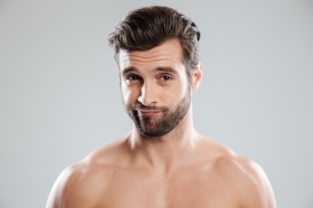 Free photo portrait of a handsome doubtful man with naked shoulders