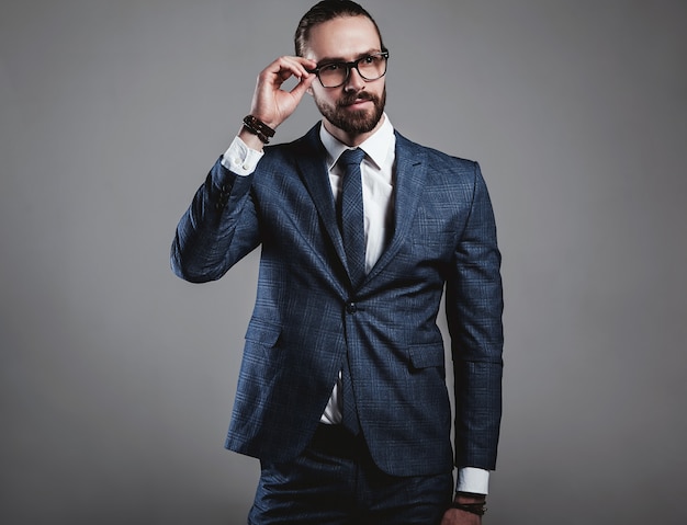 Free photo portrait of handsome fashion businessman model dressed in elegant blue suit with glasses