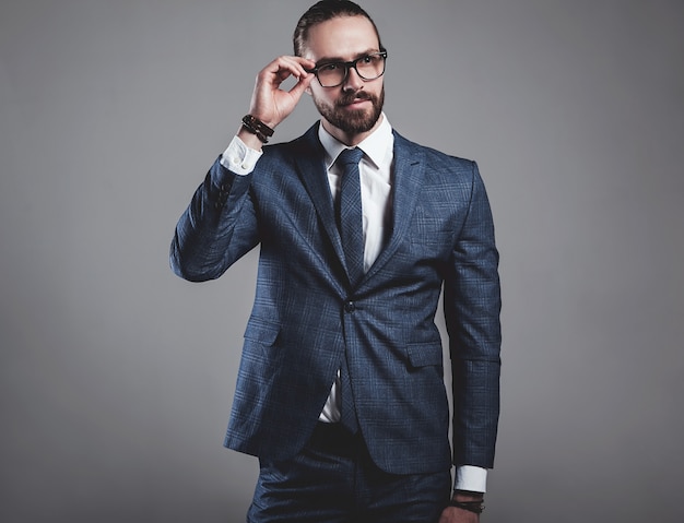 Portrait of handsome fashion businessman model dressed in elegant blue suit with glasses