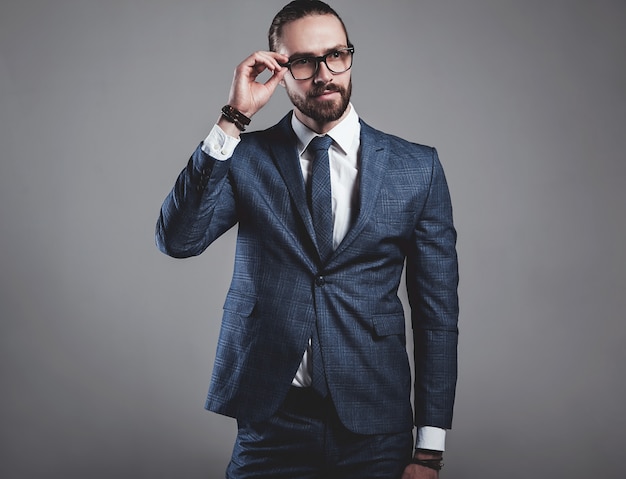 Портрет модельер красивый бизнесмен, одетый в элегантный синий костюм в очках