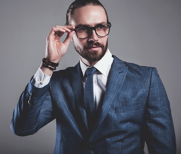 Free photo portrait of handsome fashion businessman model dressed in elegant blue suit with glasses