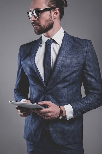 Portrait of handsome fashion businessman model dressed in elegant blue suit with glasses