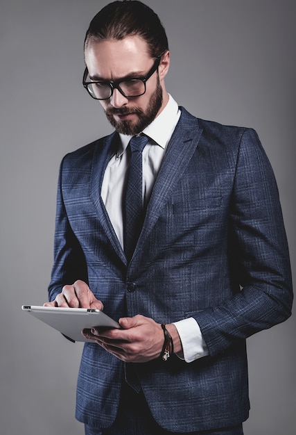 Portrait of handsome fashion businessman model dressed in elegant blue suit with glasses