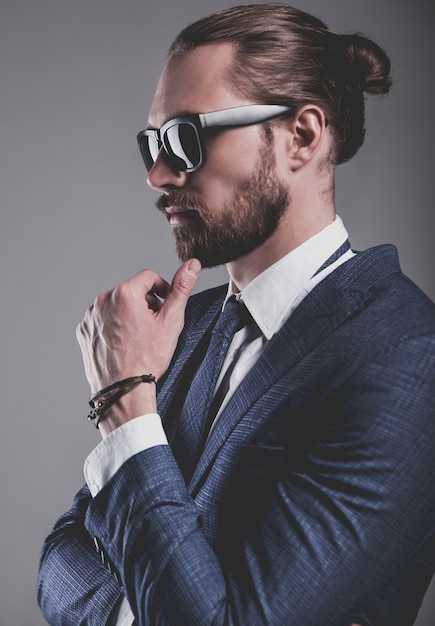 Portrait of handsome fashion businessman model dressed in elegant blue suit with glasses