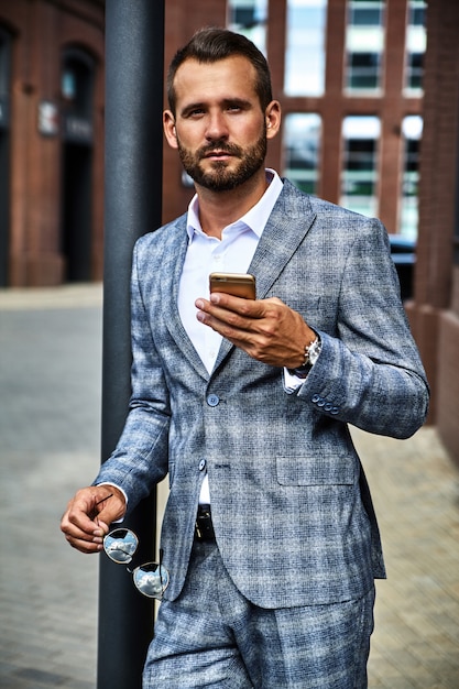 Portrait of handsome fashion businessman model dressed in elegant checkered suit