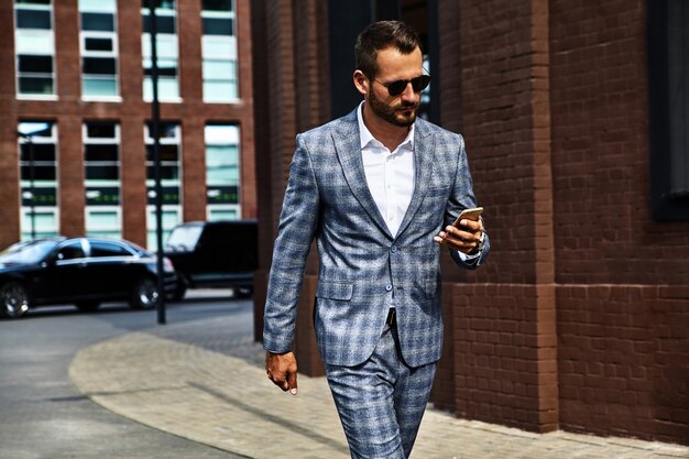 Portrait of handsome fashion businessman model dressed in elegant checkered suit