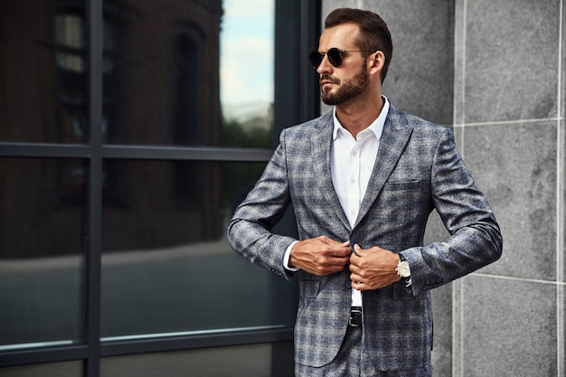 Portrait of handsome fashion businessman model dressed in elegant checkered suit