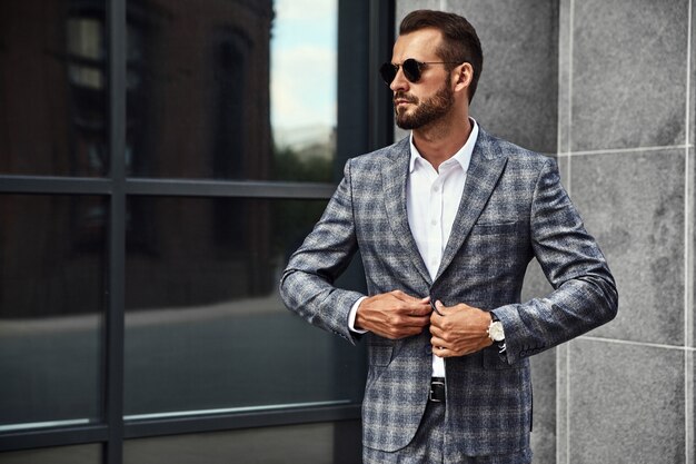 Portrait of handsome fashion businessman model dressed in elegant checkered suit