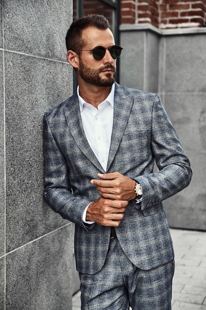 Portrait of handsome fashion businessman model dressed in elegant checkered suit