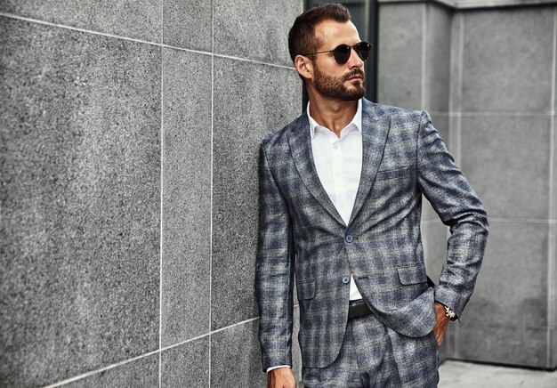 Portrait of handsome fashion businessman model dressed in elegant checkered suit