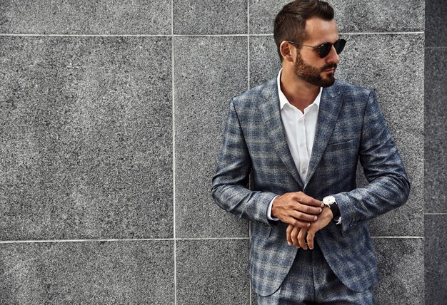 Portrait of handsome fashion businessman model dressed in elegant checkered suit