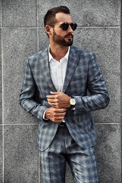 Portrait of handsome fashion businessman model dressed in elegant checkered suit
