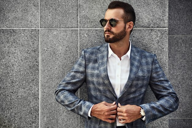 Portrait of handsome fashion businessman model dressed in elegant checkered suit