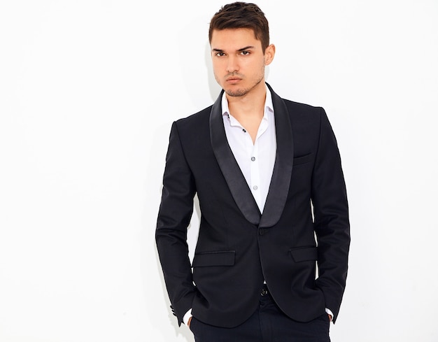 portrait of handsome fashion stylish businessman model dressed in elegant black classic suit posing. Metrosexual