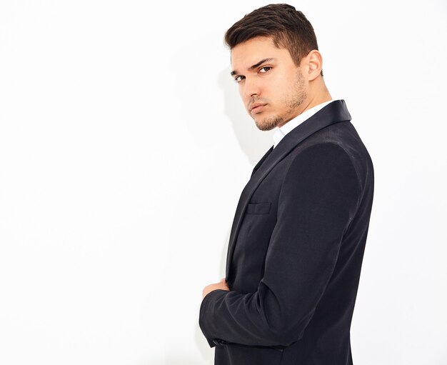 portrait of handsome fashion stylish businessman model dressed in elegant black classic suit posing. Metrosexual