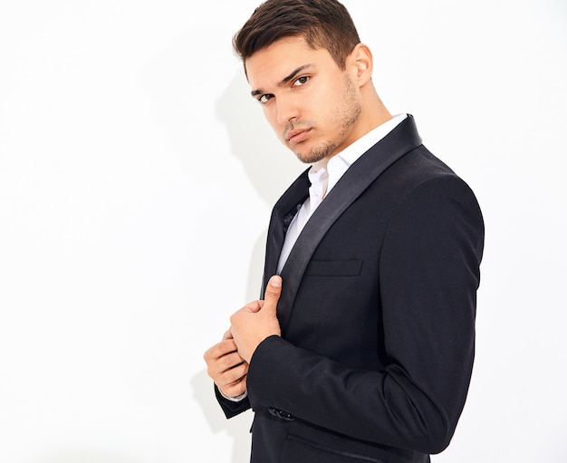 portrait of handsome fashion stylish businessman model dressed in elegant black classic suit posing. Metrosexual