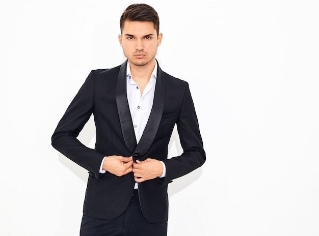 portrait of handsome fashion stylish businessman model dressed in elegant black classic suit posing. Metrosexual