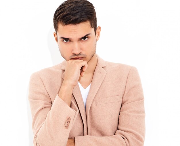 portrait of handsome fashion stylish businessman model dressed in elegant light pink suit posing. Metrosexual