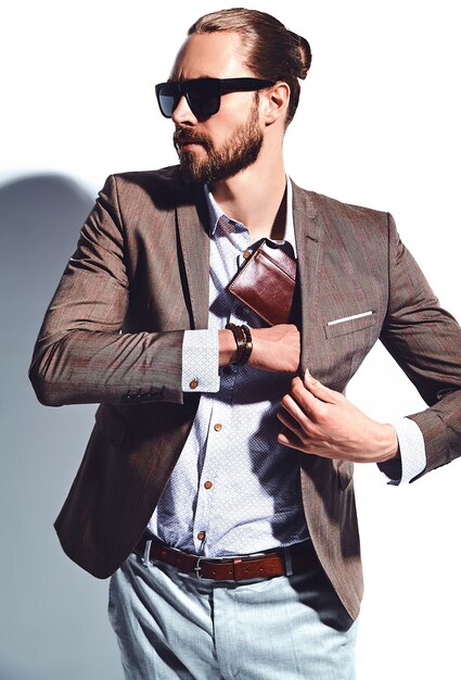portrait of handsome fashion stylish hipster businessman model dressed in elegant brown suit in sunglasses