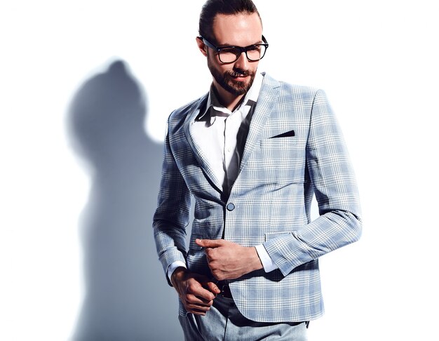 Портрет красивый модный стильный битник бизнесмен модель одет в элегантный светло синий костюм в очках на белом.