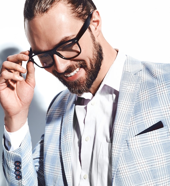 portrait of handsome fashion stylish hipster businessman model dressed in elegant light blue suit in glasses on white