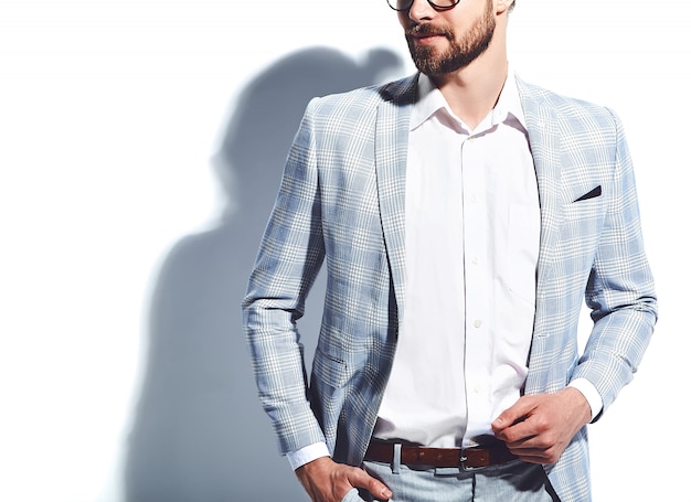 portrait of handsome fashion stylish hipster businessman model dressed in elegant light blue suit in glasses on white
