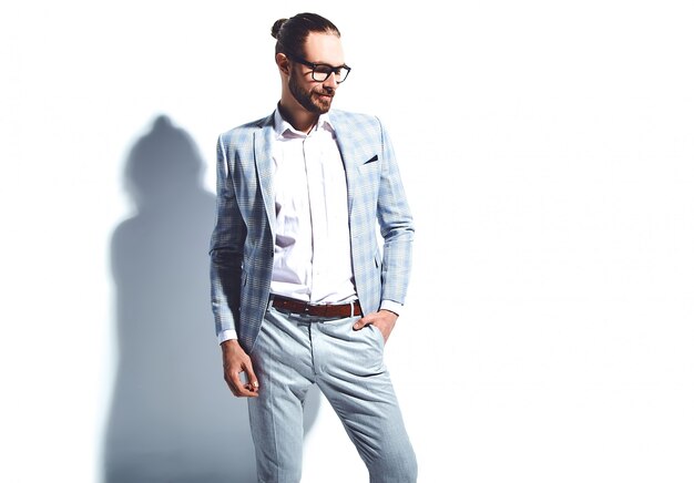 portrait of handsome fashion stylish hipster businessman model dressed in elegant light blue suit in glasses