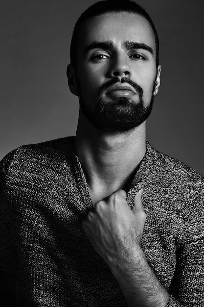 portrait of handsome fashion stylish hipster model dressed in warm sweater  posing in studio.