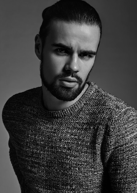 portrait of handsome fashion stylish hipster model dressed in warm sweater  posing in studio.