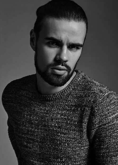 portrait of handsome fashion stylish hipster model dressed in warm sweater  posing in studio.