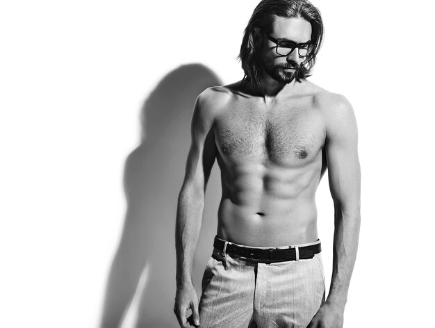 portrait of handsome fashion stylish hipster model man with bare chest in glasses on white