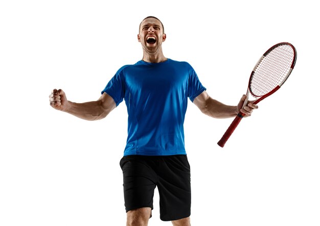 白い壁に隔離された彼の成功を祝うハンサムな男性テニスプレーヤーの肖像画。人間の感情、勝者、スポーツ、勝利の概念