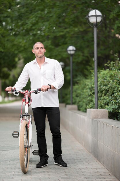 Portrait of handsome male with bicycle outdoors