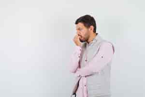 Free photo portrait of handsome man biting nails in vest, shirt and looking worried