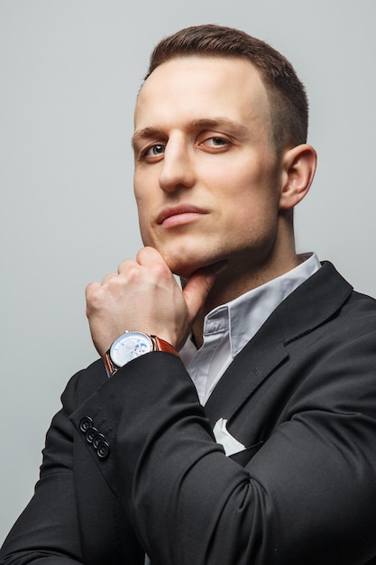 Portrait of handsome man in jacket with wrist watch on his hand