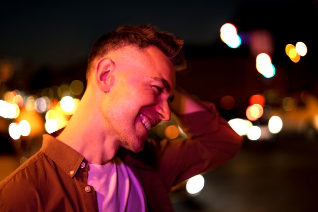 Portrait of handsome man at night in the city lights