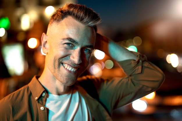 Free photo portrait of handsome man at night in the city lights