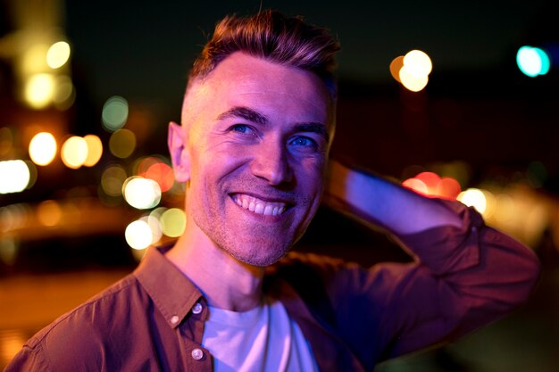 Portrait of handsome man at night in the city lights