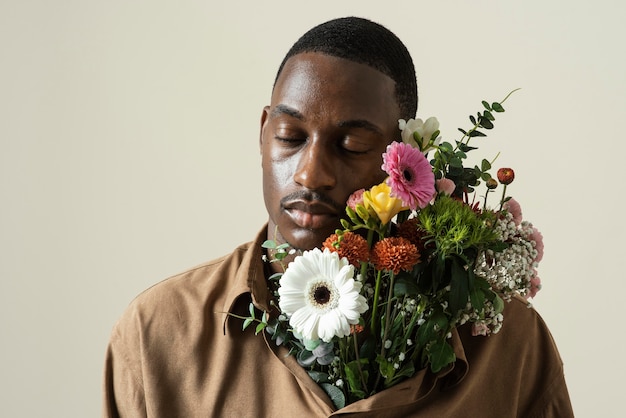 Portrait of handsome man posing with bouquet of flowers