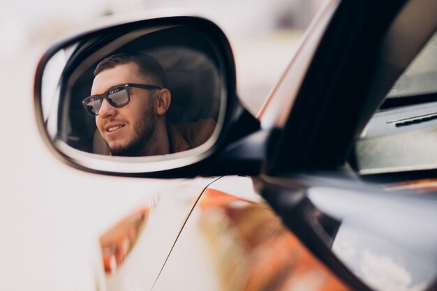 Portrait of handsome man sitting in car