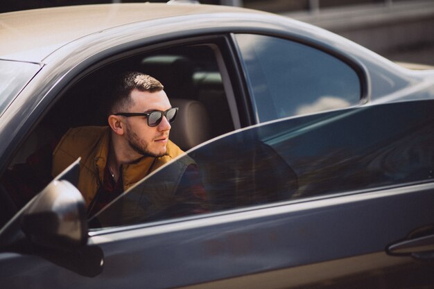 Portrait of handsome man sitting in car