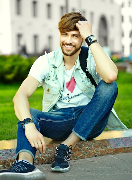 Portrait of handsome man in stylish hipster clothes. Attractive guy posing in the street